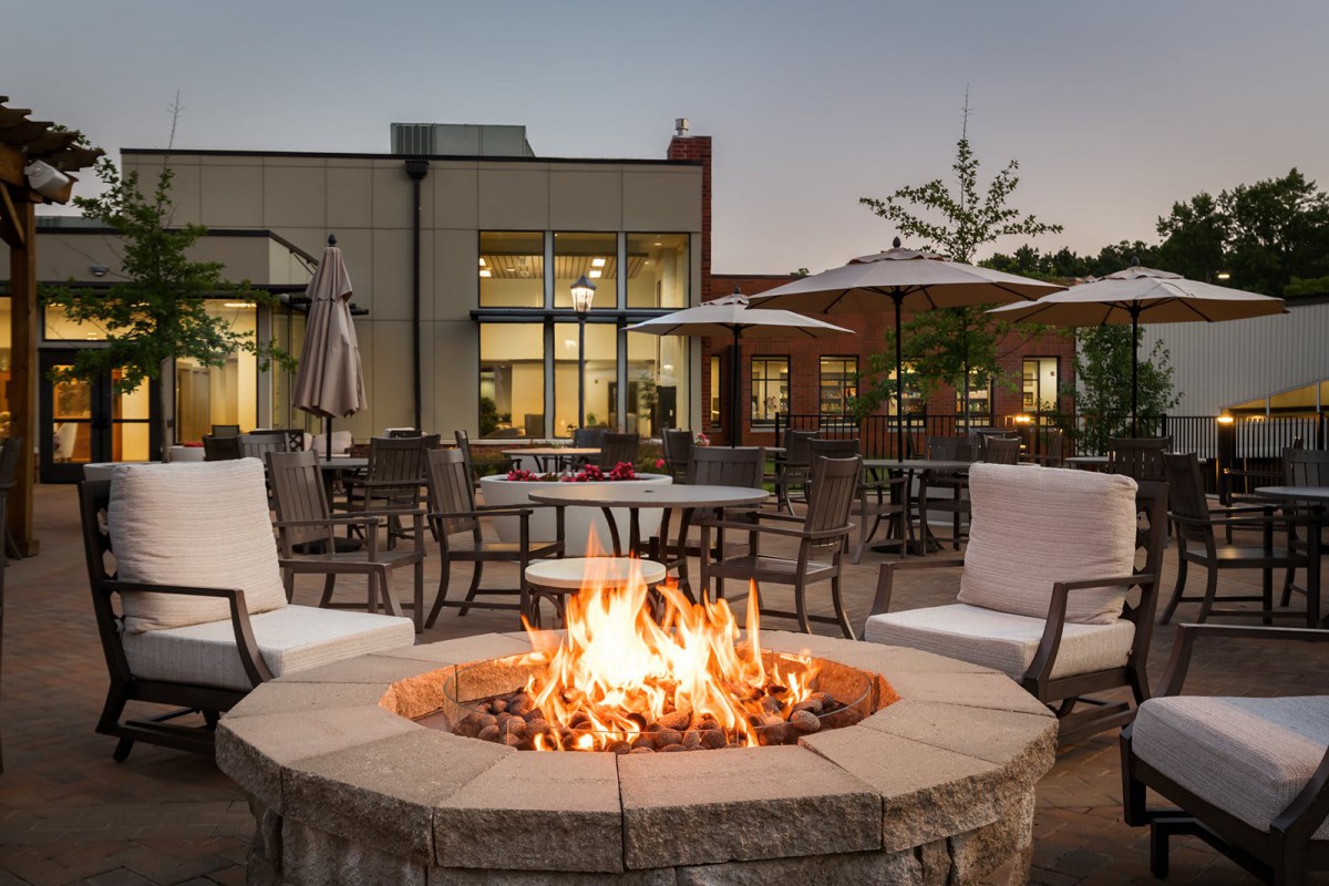 An inviting outdoor patio with a warm fire pit surrounded by comfortable seating.