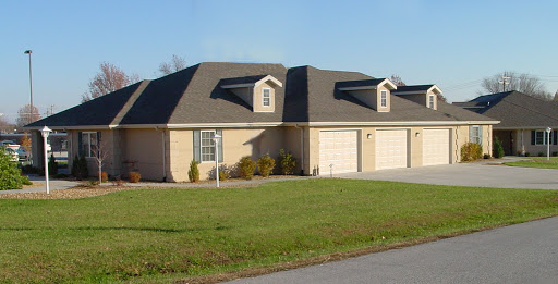 A view of a charming duplex with a well-maintained lawn in a suburban area.