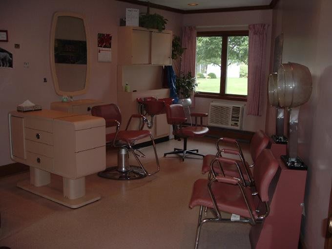 Interior of a hair salon with chairs and mirrors.