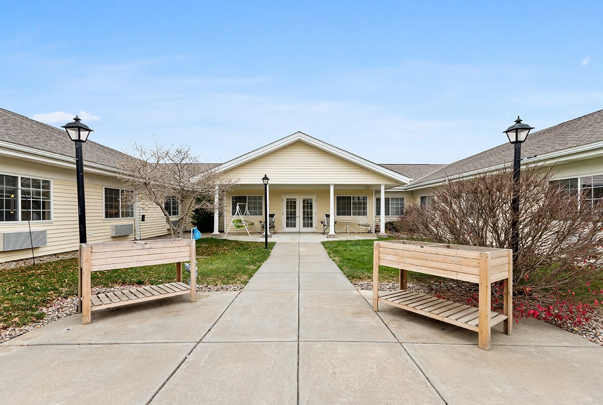 A welcoming courtyard with benches and a pathway leading to a building entrance.