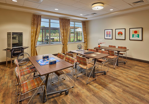 A well-lit meeting room with modern furnishings, featuring tables and chairs arranged for group activities.