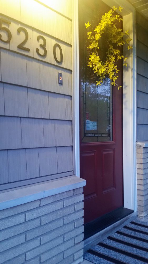 A home entrance featuring a red door and siding.