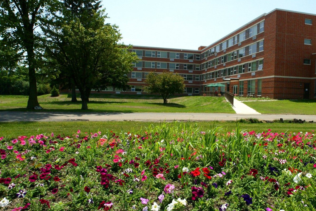 A landscape view of a building with a flower garden in the foreground.
