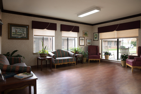 A cozy and well-lit living room space with comfortable seating and decorative plants.
