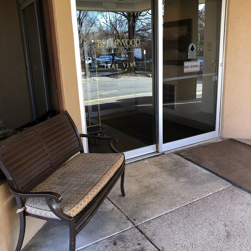 A welcoming entrance featuring a bench beside glass doors.