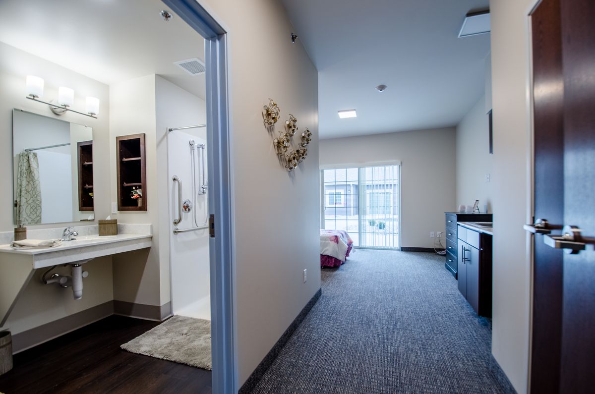 A modern room with a view of both the bedroom and bathroom areas, featuring contemporary furniture and decor.