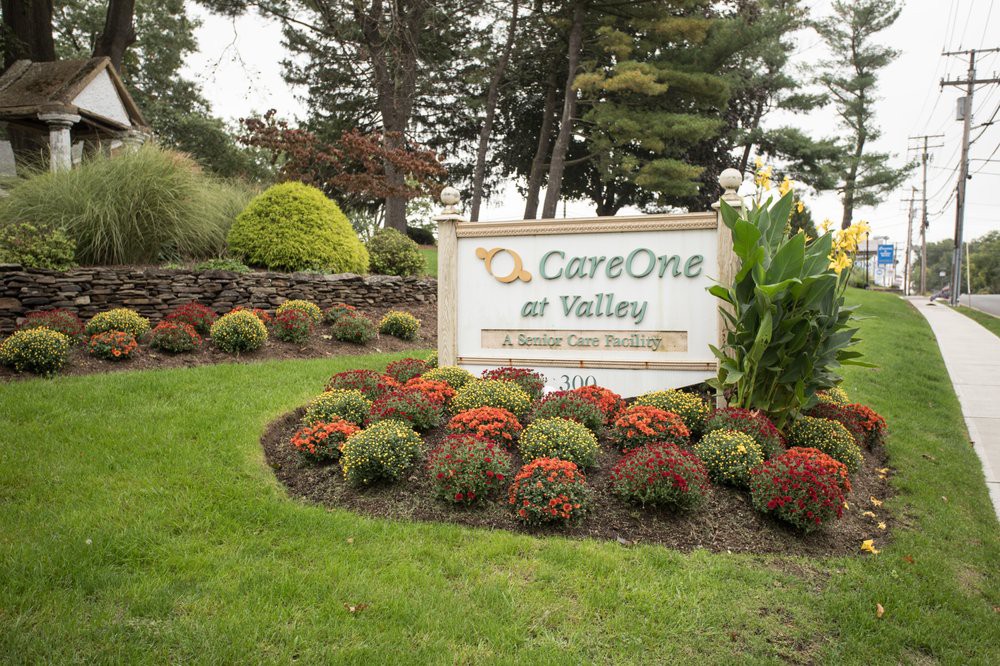 A beautifully landscaped garden with a sign for CareOne at Valley.