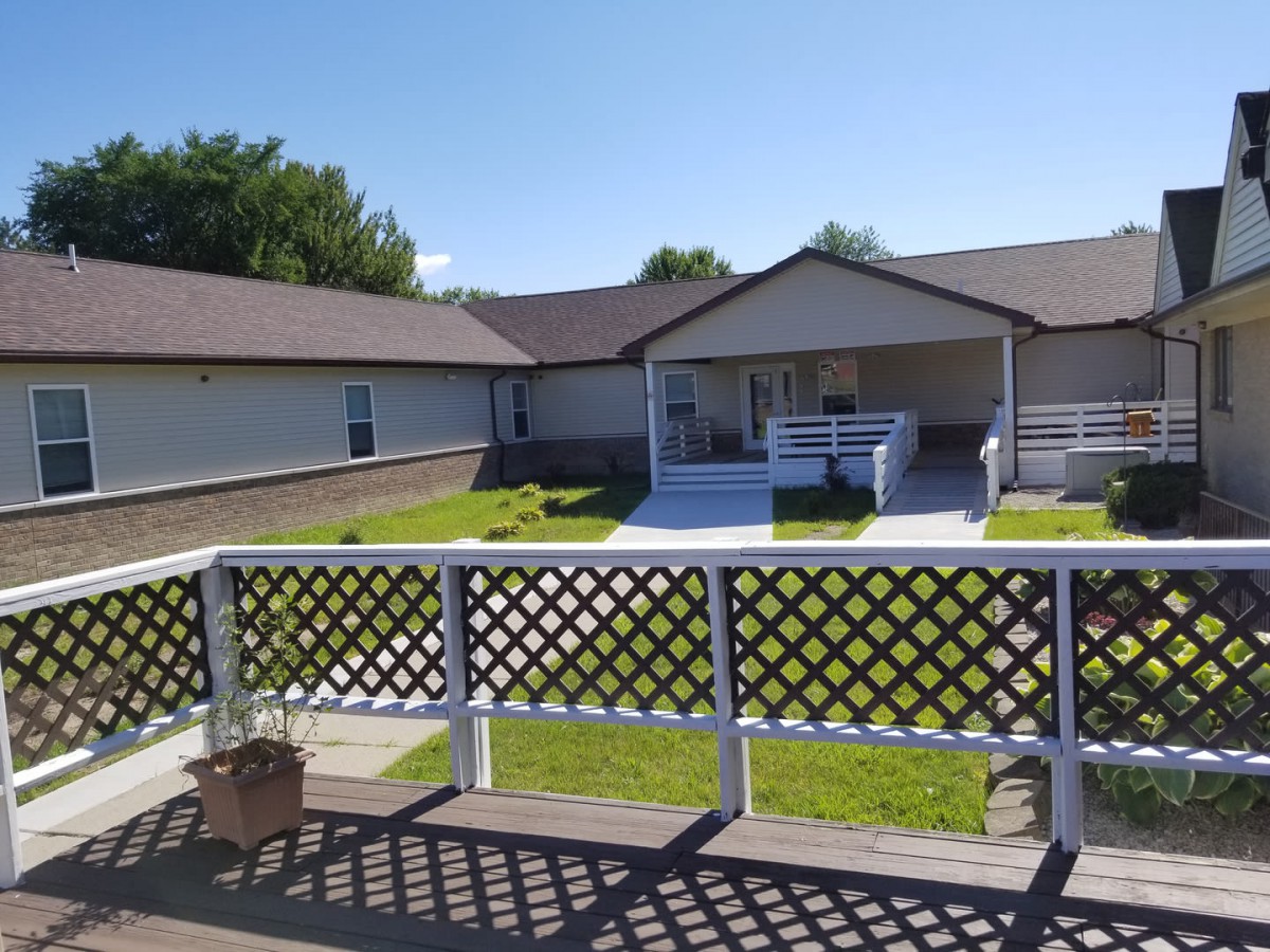 A residential building with a yard and a clear blue sky.