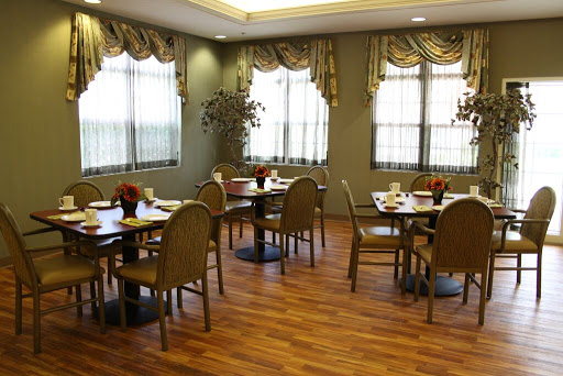 A cozy dining area featuring neatly arranged tables and chairs, complemented by natural light from the windows.