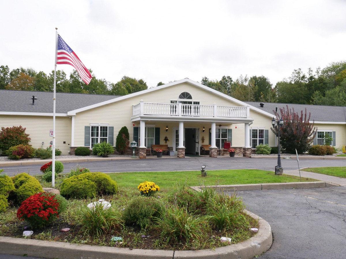 A building with a landscaped entrance and an American flag.