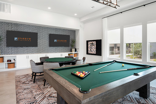 A stylish game room featuring a green pool table and contemporary furnishings, perfect for leisure and entertainment.