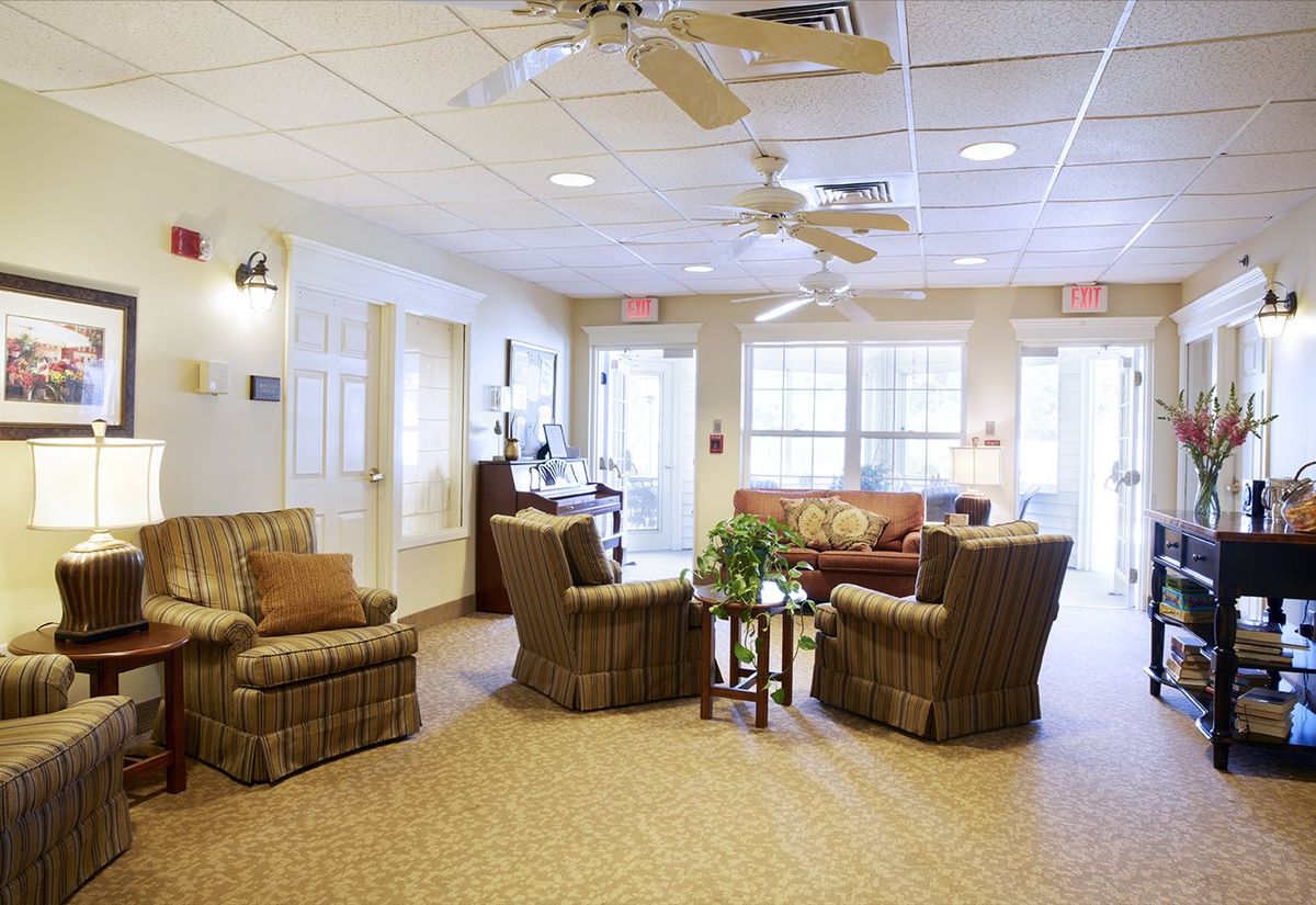 A cozy living room with comfortable seating and ceiling fans.