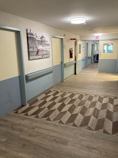 A well-maintained interior hallway with painted walls, decorative artwork, and patterned flooring.