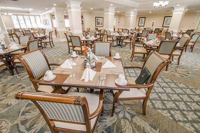 An elegant restaurant dining room with neatly arranged tables and chairs.