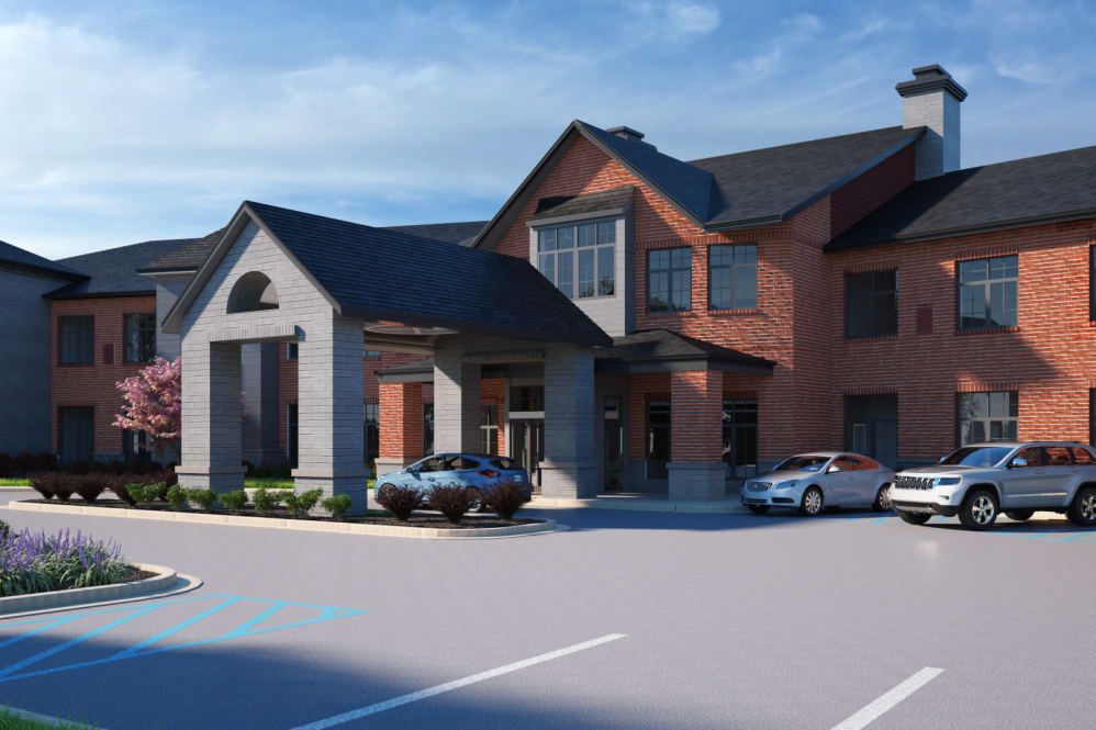 A modern residential building with a parking lot and cars in front.