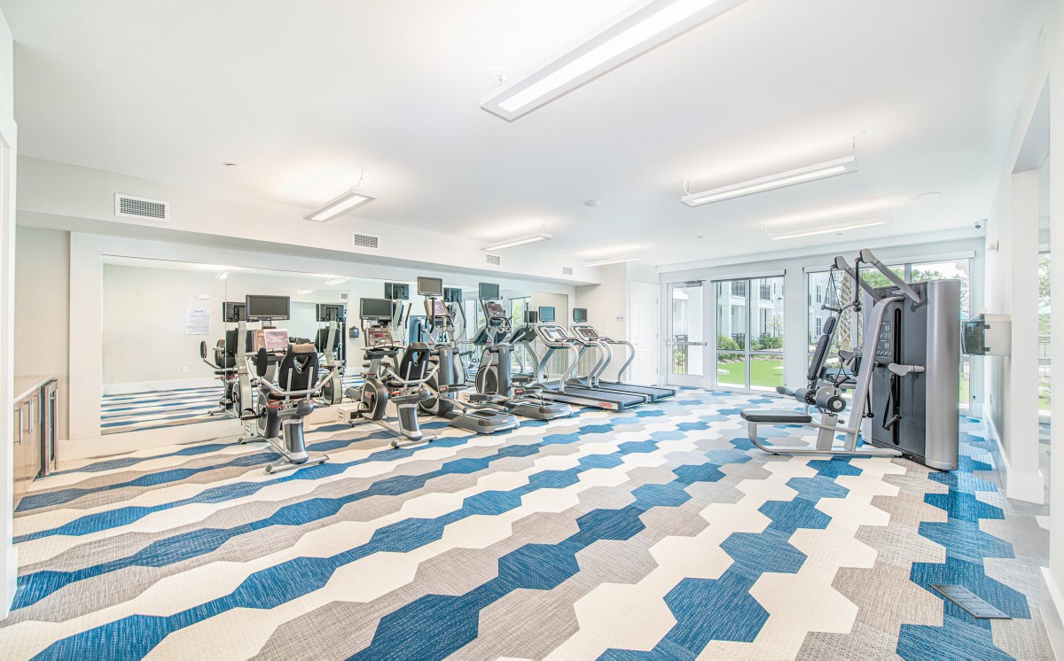 A modern gym with exercise equipment and stylish flooring.