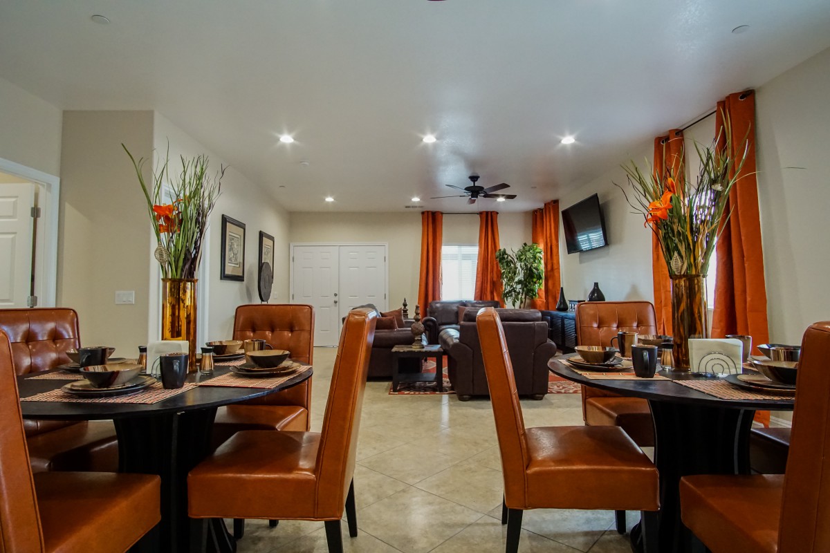 A modern dining room with neatly arranged tables and chairs, featuring stylish decor and lighting.