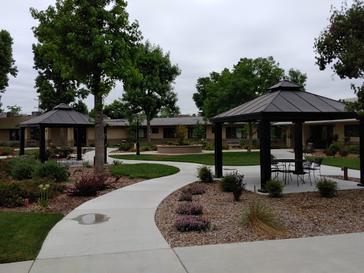 A serene park featuring well-maintained pathways, gazebos, and lush greenery.