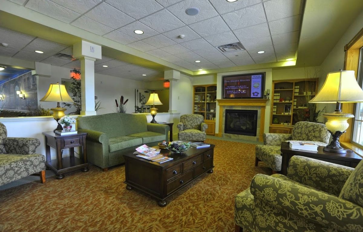 A cozy living room with comfortable seating, a fireplace, and bookshelves.