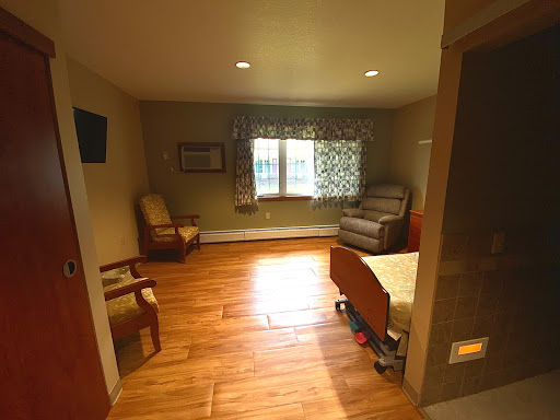 A cozy and well-lit room featuring wooden flooring and comfortable furniture.