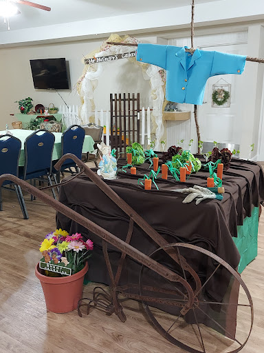 A beautifully arranged farm-themed table setup, featuring colorful flowers, greenery, and decorative elements.