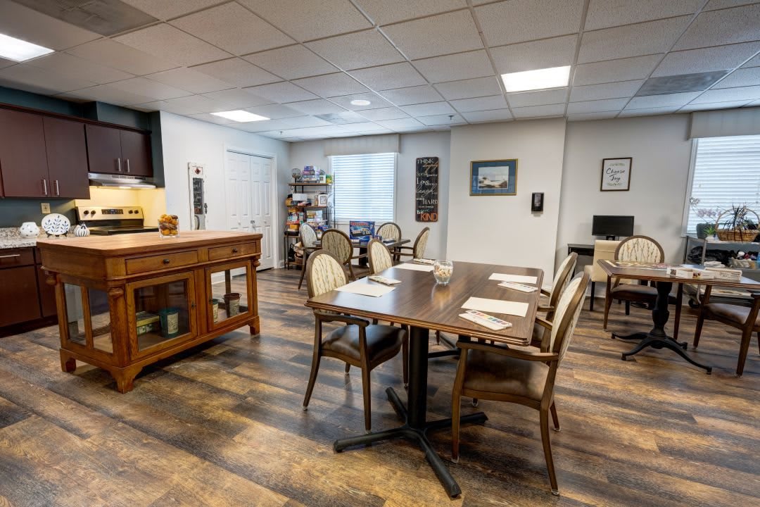 A well-arranged dining room with wooden flooring and a set of tables and chairs.