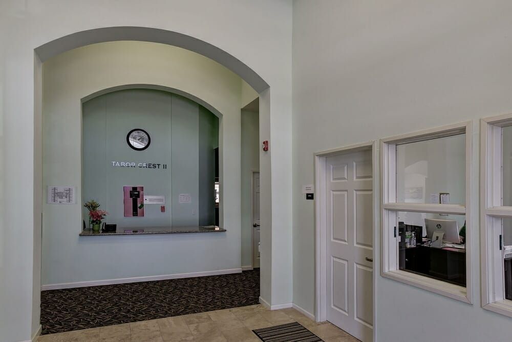 A reception area with a front desk and a clock on the wall.
