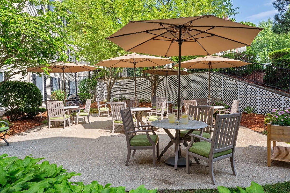 A serene outdoor patio area with tables, chairs, and umbrellas.