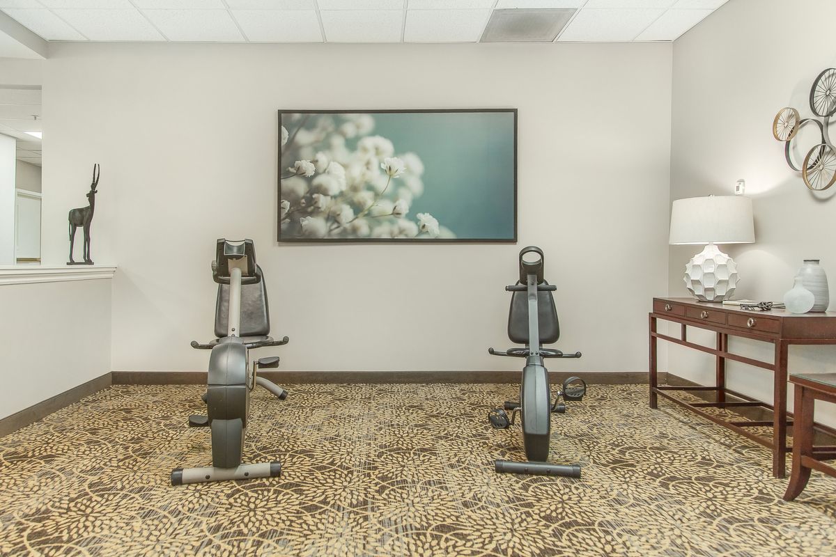 A minimalist gym with exercise bikes and a large artwork on the wall.