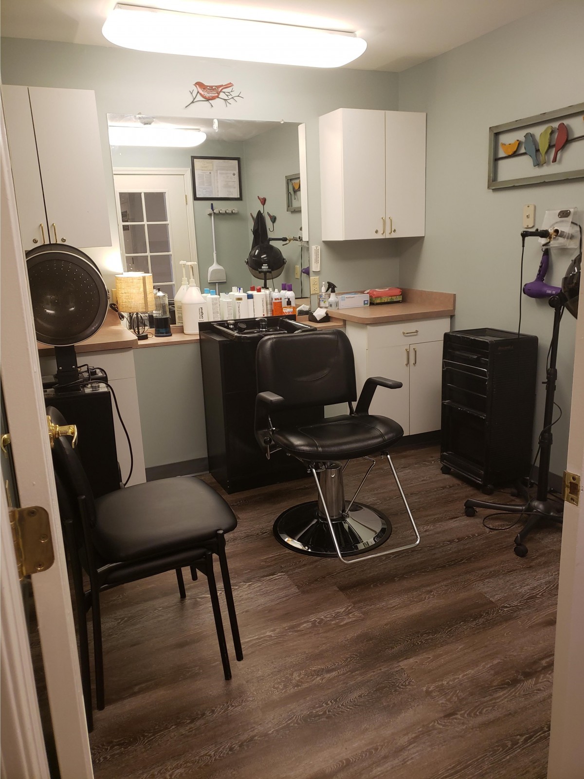 Cozy hair salon interior with a styling chair and equipment.