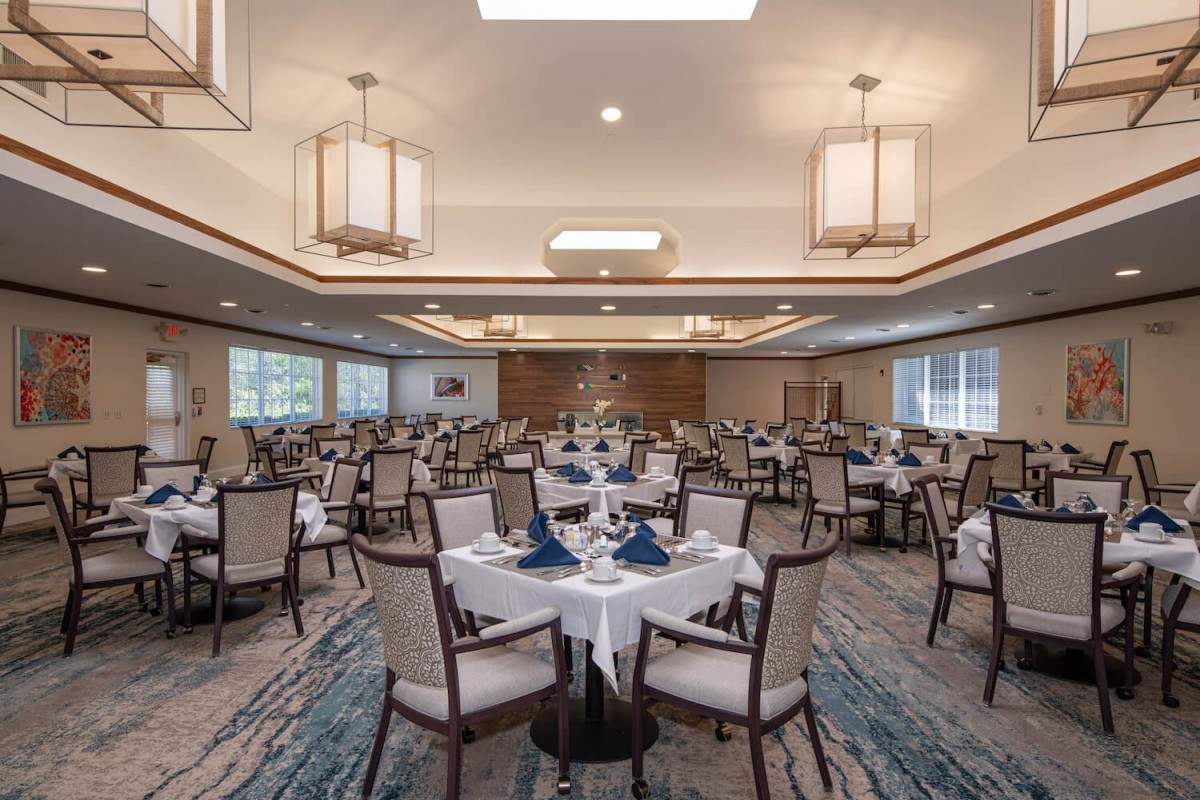 An elegant dining room set up with tables and chairs, featuring sophisticated decor and lighting.