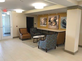 A cozy lobby with comfortable chairs and artwork on the walls.