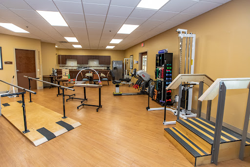 A well-equipped physical therapy room featuring various exercise and rehabilitation equipment.