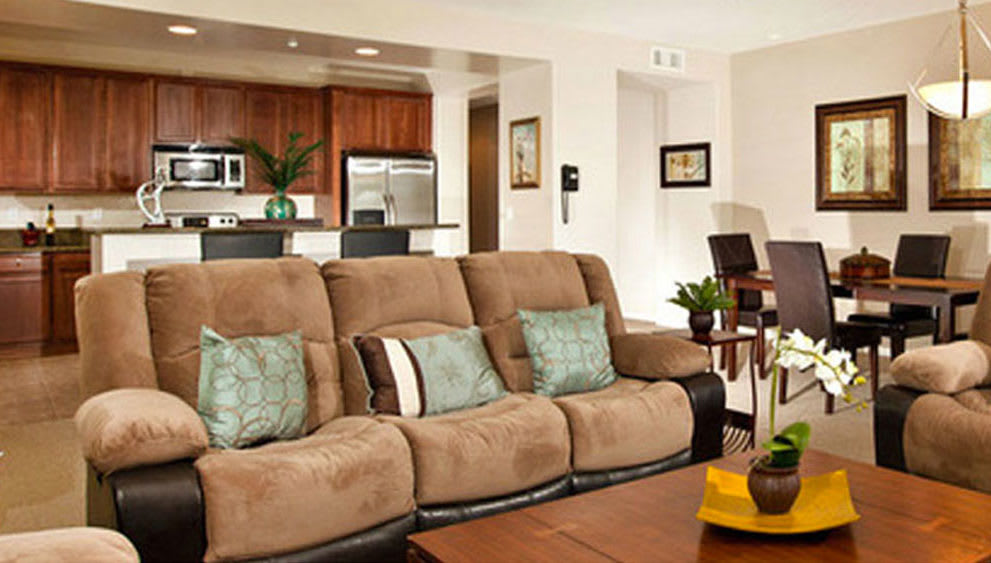 An open-concept living room with a cozy sofa and connected kitchen area.