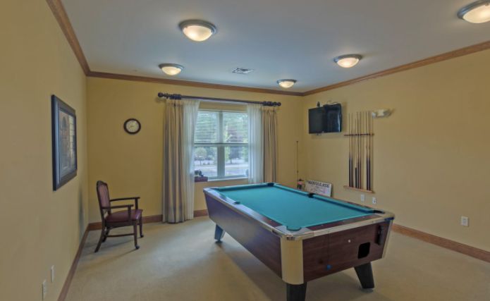 A cozy game room featuring a pool table and television.