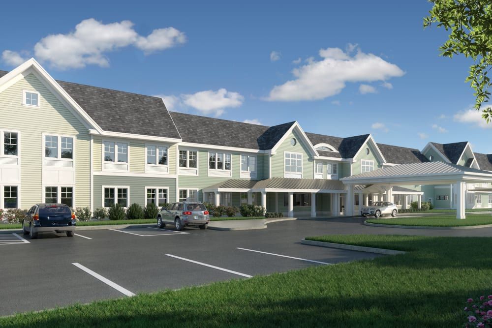 A modern residential building with a spacious parking lot under a partly cloudy sky.