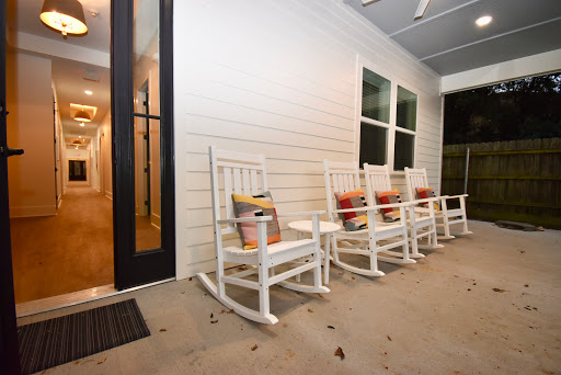 A serene porch featuring inviting rocking chairs, perfect for moments of relaxation.