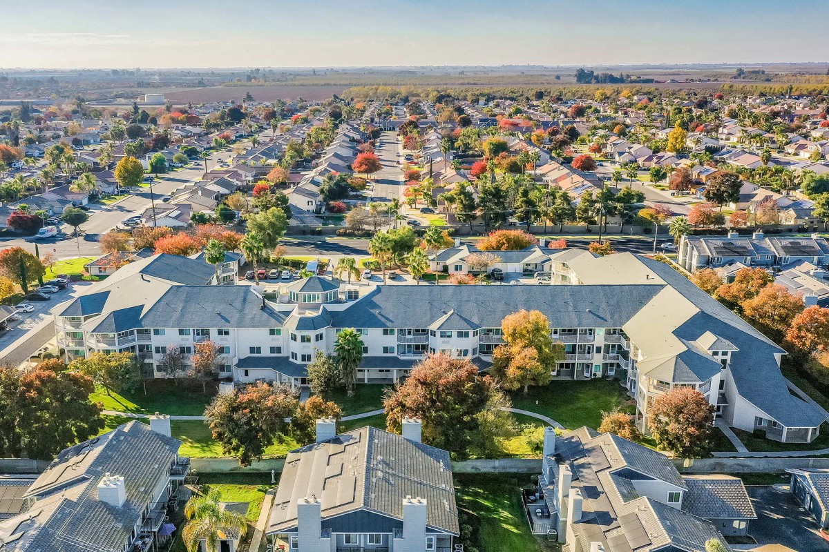 Aerial view of a suburban neighborhood with houses and autumn foliage.