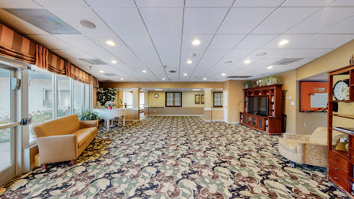 A spacious and well-lit lobby area with floral-patterned carpeting, inviting seating arrangements, and a welcoming atmosphere.