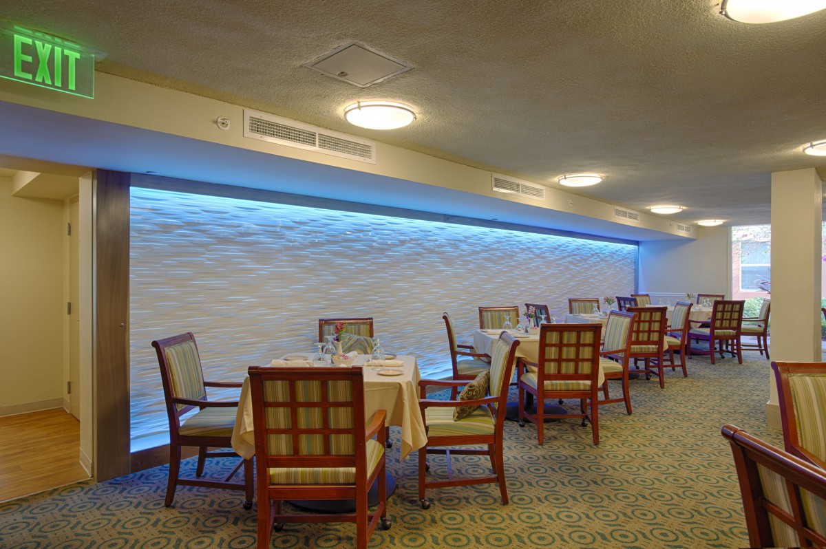 An elegant dining area in a restaurant with neatly arranged tables and chairs, featuring stylish interior lighting.