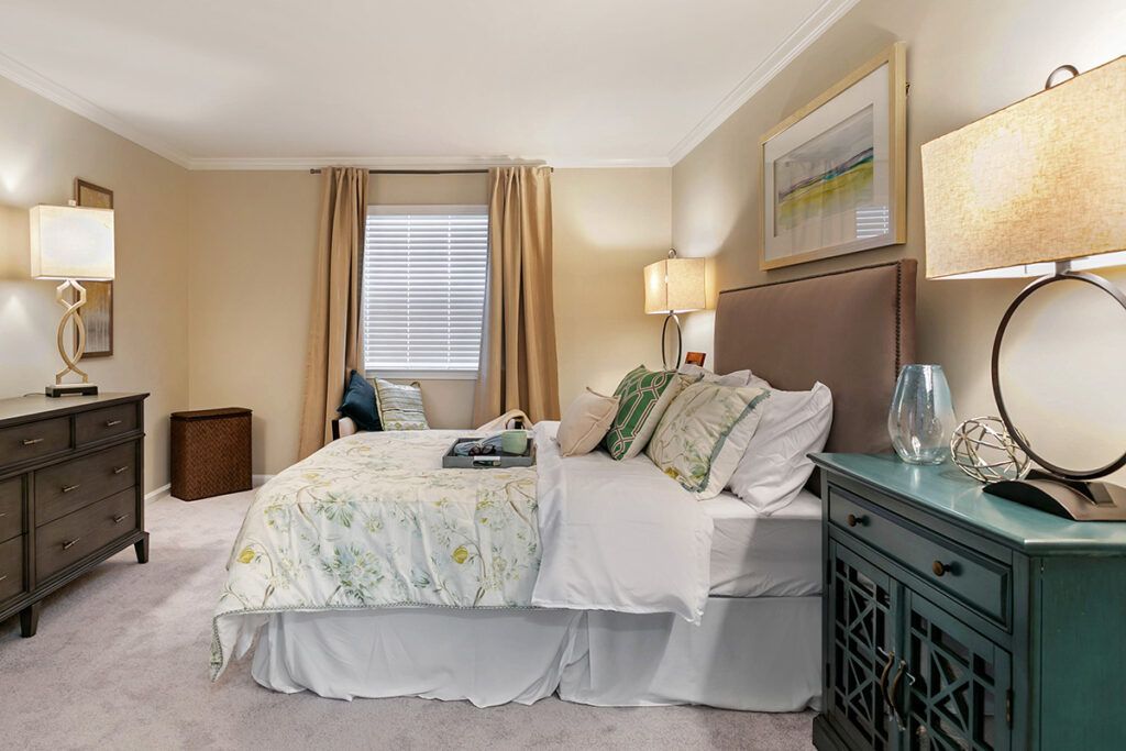 A well-decorated bedroom with a large bed, pillows, and ambient lighting.
