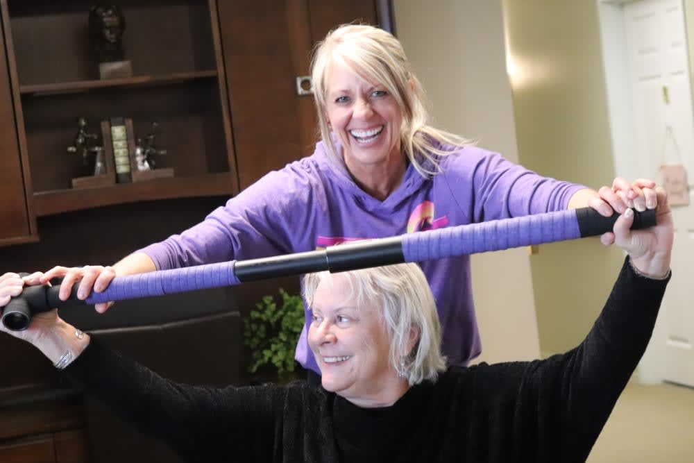 Two women engaging in a joyful exercise session indoors.