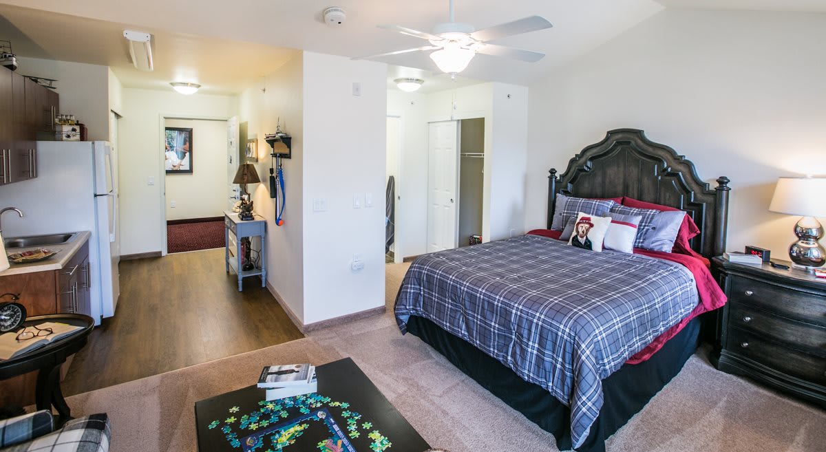 A cozy bedroom with a plaid bedspread, featuring modern decor and furniture.