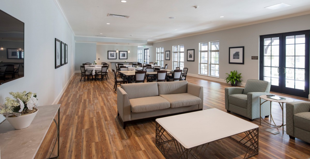 Spacious lounge area with comfortable seating and wooden flooring.