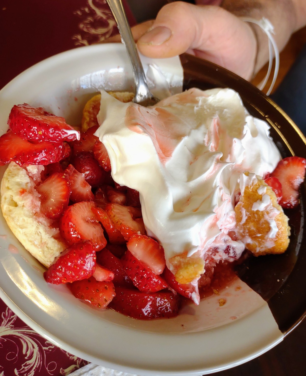 A delicious dessert featuring pancakes topped with fresh strawberries and whipped cream.
