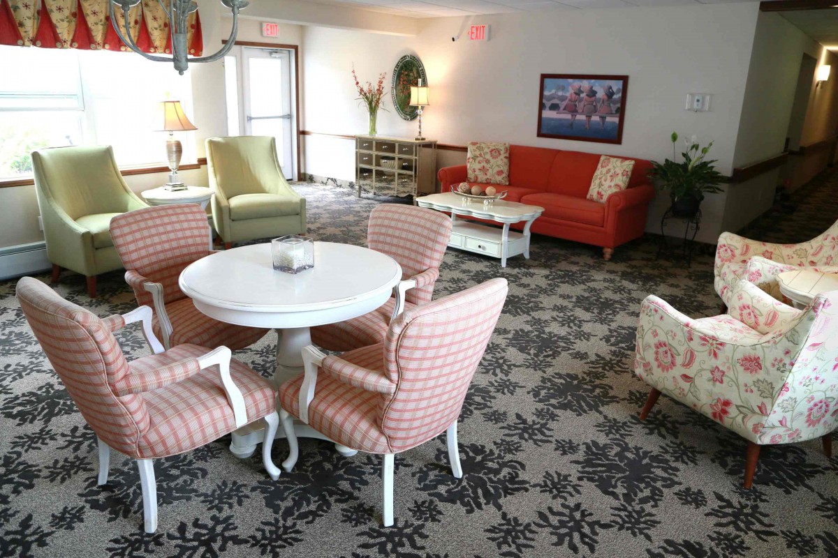 Cozy living room with colorful furniture and patterned carpet.