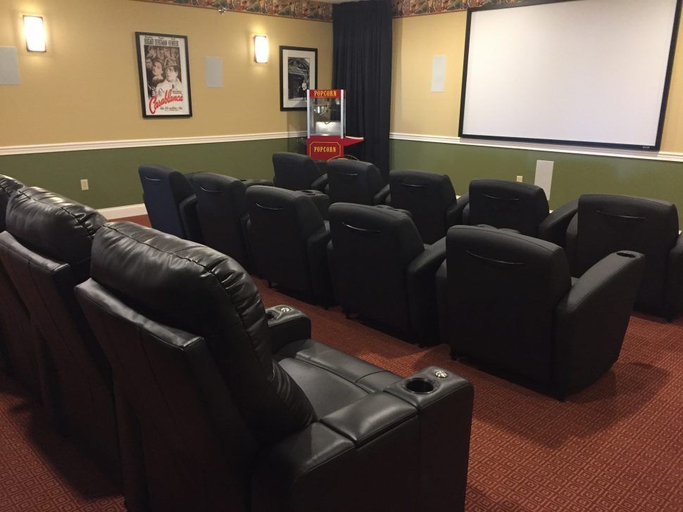 A cozy home theater setup with comfortable recliners and a large projection screen.
