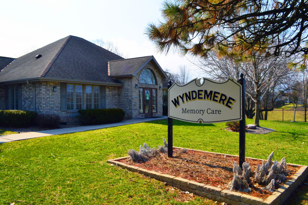 A building with a sign reading 'Wyndemere Memory Care' surrounded by neatly maintained landscaping.