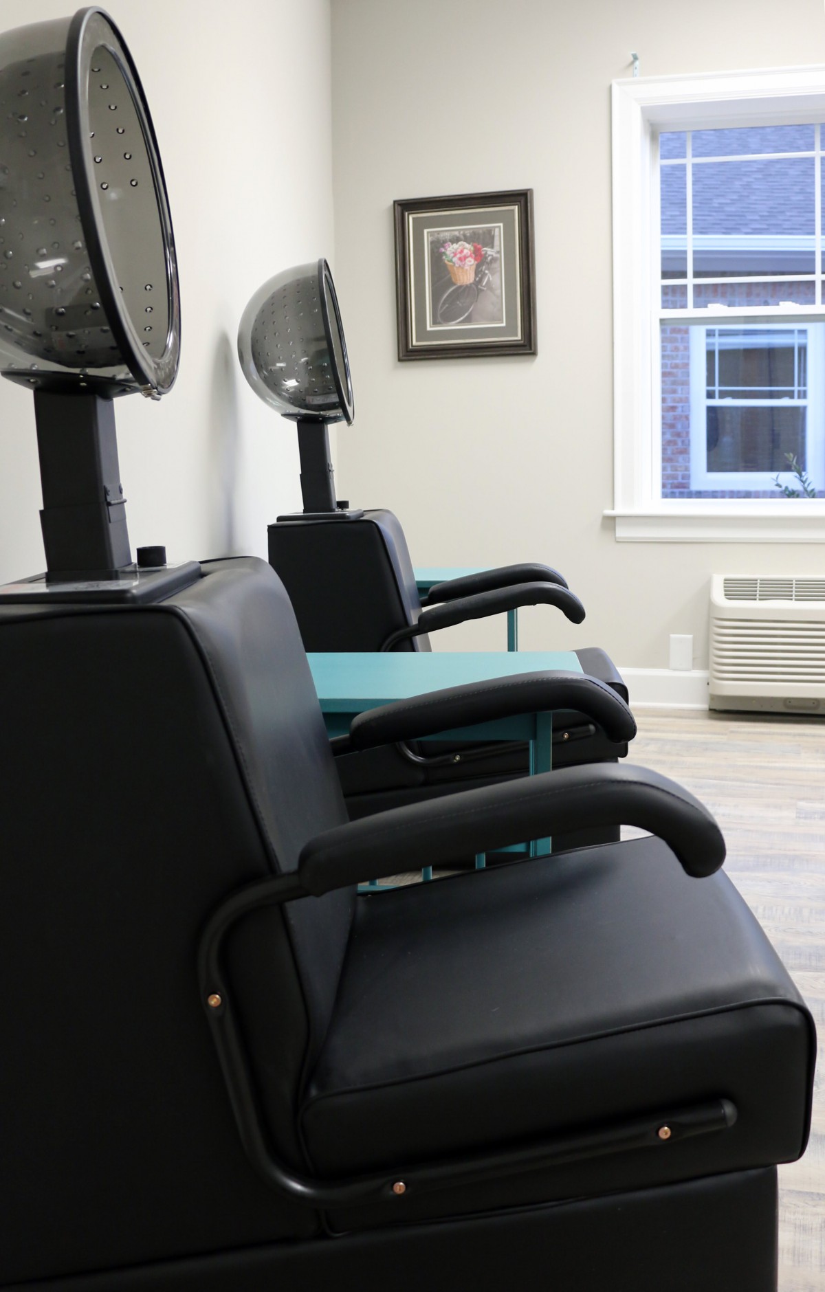 Empty salon chairs with hair dryers in a beauty salon.