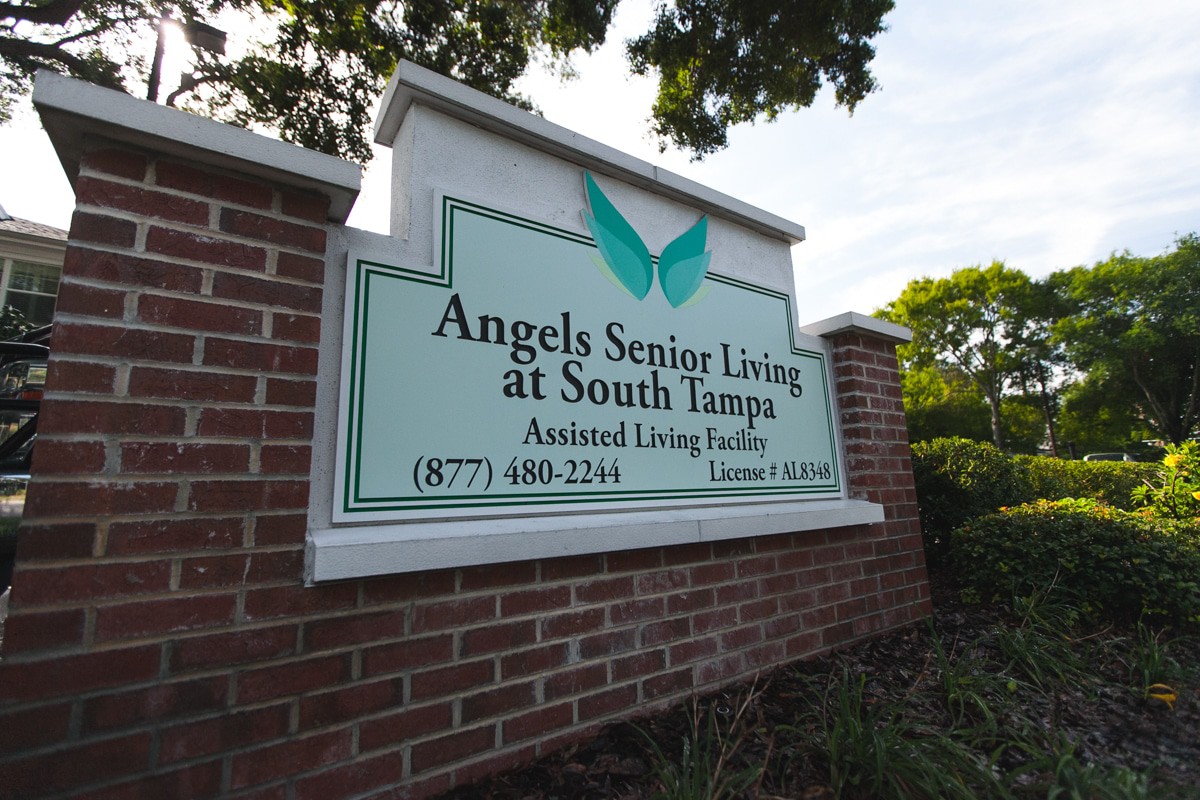 A sign for Angels Senior Living at South Tampa, located on a brick wall.